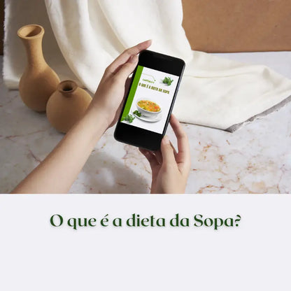 Mulher lendo no celular o capítulo do e-book sopa para emagrecer - um guia para iniciantes que fala sobre o que é a dieta